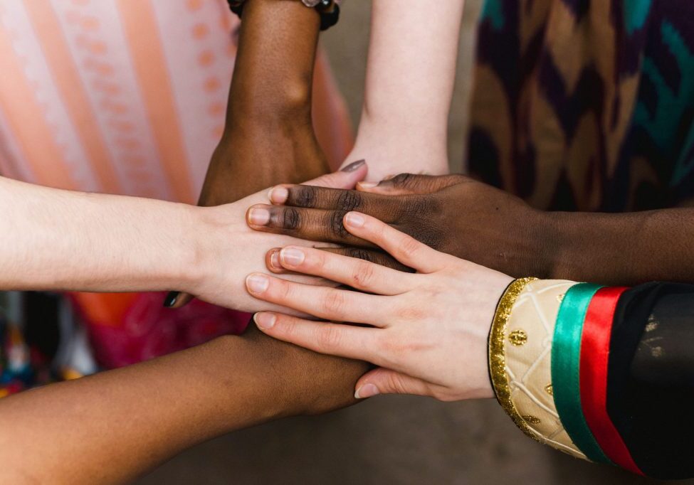 National diversity. People of different appearance and nationality stand in a circle together and hold hands. Team building and partnership business concept