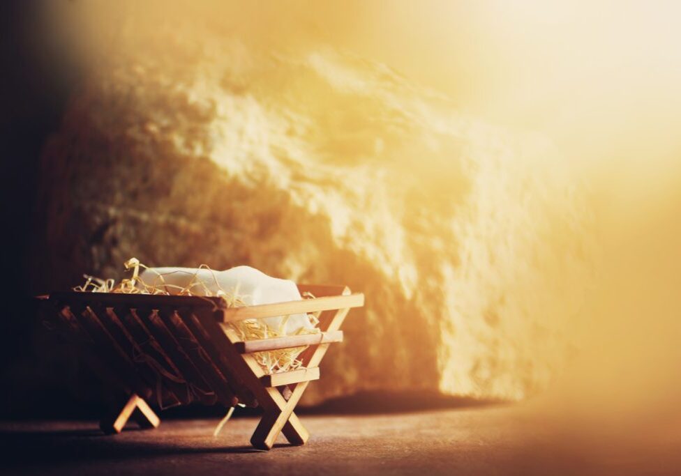 Wooden manger and star of Bethlehem in cave, nativity scene background. Christian Christmas concept. Birth of Jesus Christ. Jesus is reason for season. Salvation, Messiah, Emmanuel, God with us, hope.